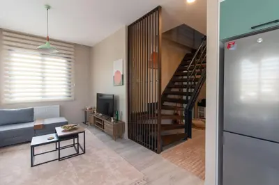 a living room with a couch and a stair case at Göktürk's Finest 2BR Stylish, Spacious & Prime in Kemerburgaz