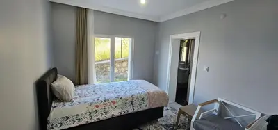a bedroom with a bed and a window at Luxury villa with sea and forest view in Döngel