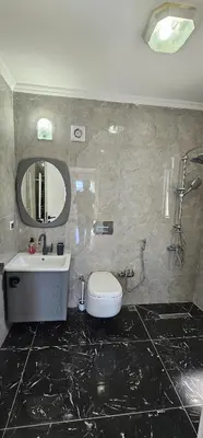 a bathroom with a sink and a toilet and a mirror at Luxury villa with sea and forest view in Döngel
