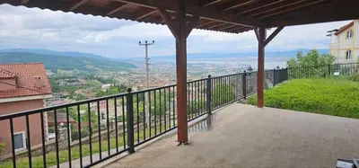 a balcony with a view of a city at Luxury villa with sea and forest view in Döngel