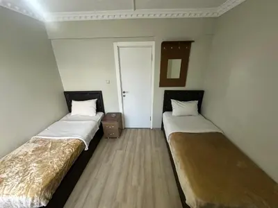 two beds in a small room with a door at Şebnem Hotel in Istanbul