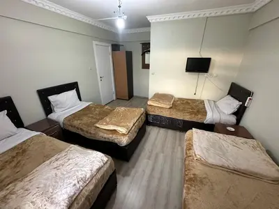 a hotel room with three beds and a flat screen tv at Şebnem Hotel in Istanbul