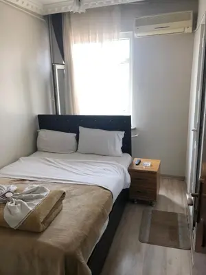 a bedroom with a large bed with a window at Şebnem Hotel in Istanbul