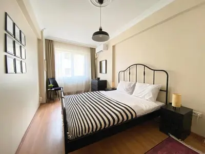 a bedroom with a bed with a black and white striped blanket at City Center Spacious Flat No9 in Istanbul