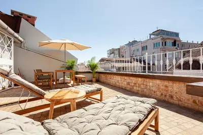 a balcony with chairs and tables and an umbrella at Roof top, close to Taksim, with private terrace in Istanbul