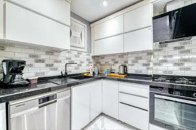 a white kitchen with white cabinets and appliances at Bright Apart Hotel in Istanbul
