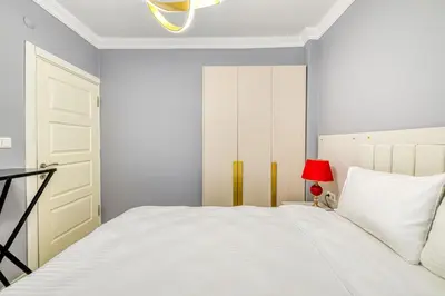 a bedroom with a white bed and a red lamp at Bright Apart Hotel in Istanbul