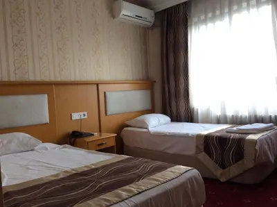 a hotel room with two beds and a window at Ilıcak Hotel in Istanbul