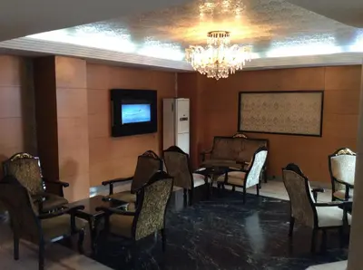 a waiting room with chairs and a tv and a chandelier at Ilıcak Hotel in Istanbul