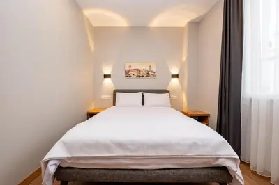 a bedroom with a large white bed with two lamps at The Han YK Hotel in Avcılar