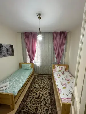 two beds in a room with pink curtains at Hostel Nelly in Istanbul