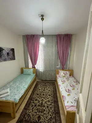 two beds in a room with pink curtains at Hostel Nelly in Istanbul