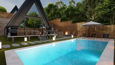 a swimming pool with a fireplace next to a house at Redka Bungalov Resort in Ulupelit