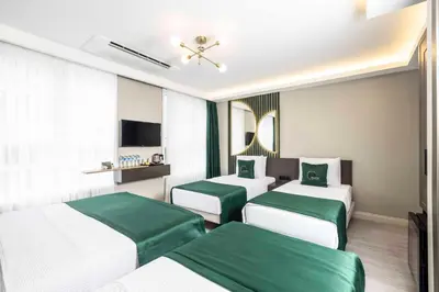 a hotel room with three beds and a television at Sistina Old City Hotel in Istanbul