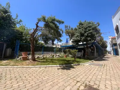 a cobblestone street with two trees and a building at Enn Is Inn Hotel in Marmaraereglisi