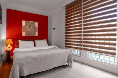 a bedroom with a bed and a red wall at Boho-Chic 1BR in Firuzaga - Near Galata in Istanbul