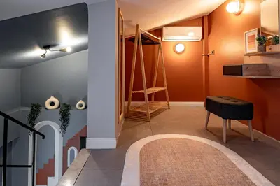 a hallway with orange walls and a stair case at Luxury 1BR Duplex with Terrace & Office in Tomtom in Istanbul