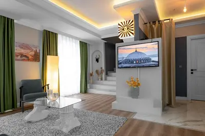 a living room with a picture of a building on the wall at Luxury 1BR Duplex with Terrace & Office in Tomtom in Istanbul