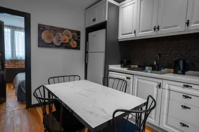 a kitchen with white cabinets and a table and chairs at Designed 2BR Rooftop Duplex with Private Terrace in Istanbul