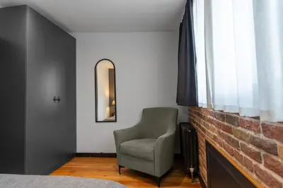 a bedroom with a chair and a brick wall at Designed 2BR Rooftop Duplex with Private Terrace in Istanbul