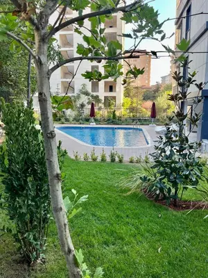 a swimming pool in a yard with a tree at Köylüm Bostanci Residence-3 in Istanbul