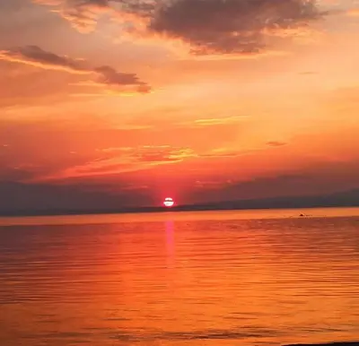 a sunset over the ocean with the sun setting at Kum Motel in Marmara
