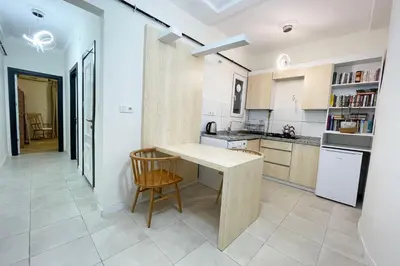 a kitchen with a wooden table and a counter at cozy 2BR 2BATH with balcony near to nişantaşi and taksim #4 in Istanbul