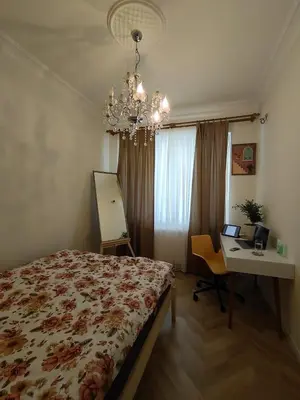 a bedroom with a bed and a desk and a chandelier at balcony 2BR apt near to nişantaşi #2 in Istanbul