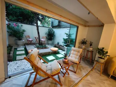 a living room with chairs and a large window at baesment 2BR apt with 2toilet and 2bath 8min to metro #1 in Istanbul