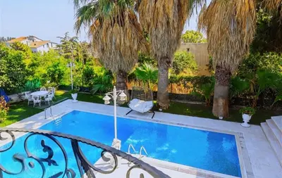 a swimming pool in a yard with palm trees at Cloud Nine by Alara - Luxury Private Pool and Garden Villa in Beylikduzu