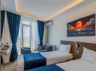 a hotel room with two beds and a window at Airport Waves Hotel in Arnavutköy