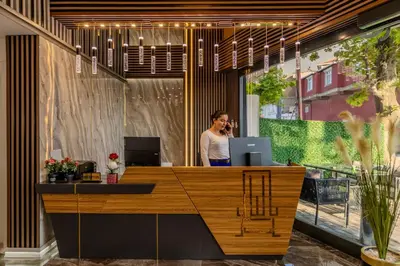a man talking on a phone in an office at Airport Waves Hotel in Arnavutköy