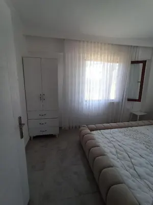 a white bedroom with a large bed and a dresser at Kandıra villam in Duraklı