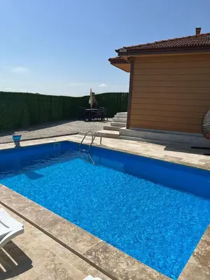 a small blue swimming pool next to a house at Kandıra villam in Duraklı
