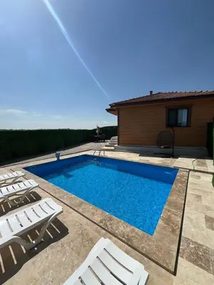 a swimming pool with chairs and a house at Kandıra villam in Duraklı