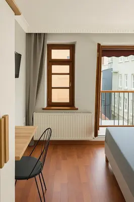 a room with a bed and a table and a window at PeraHomes in Istanbul