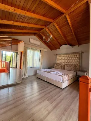 a bedroom with a large bed in a room with wooden ceilings at Gizemli Nehir Bungalov Otel in Agva