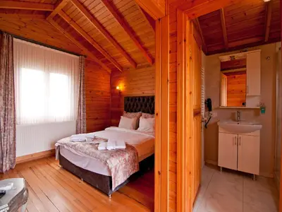 a bedroom with a bed and a sink in a room at Gizemli Nehir Bungalov Otel in Agva