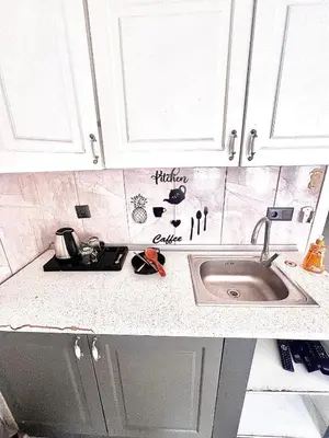 a kitchen counter with a sink and white cabinets at Taksim Luxury Capital Hotel in Istanbul