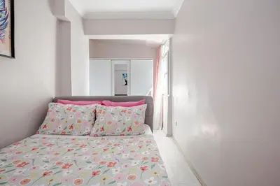 a small bedroom with a bed with pink pillows at Kadıköy ün Kalbinde Tarihi Rahat Sessiz Daire in Istanbul