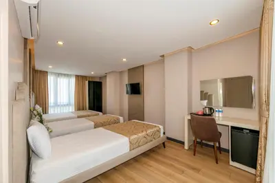 a hotel room with a bed and a desk at Hilltown Airport Hotel & Restaurant in Taşoluk