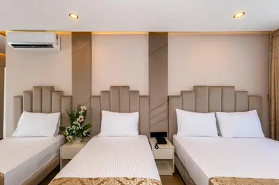 two beds in a hospital room with flowers between them at Hilltown Airport Hotel & Restaurant in Taşoluk