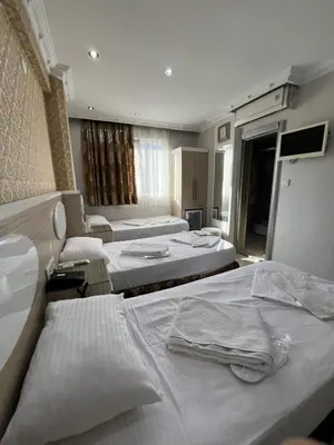 a hotel room with three beds and a sink at ORAL hotel in Istanbul