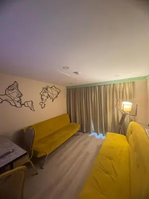 a hotel room with a yellow couch and a window at Taksim Tekir Apartment in Istanbul