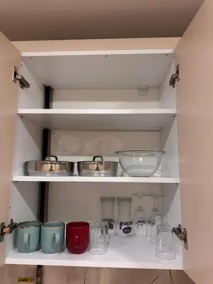 a shelf with bowls and other glass items on it at Taksim Tekir Apartment in Istanbul