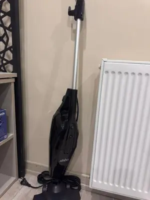a black vacuum in a room next to a radiator at Taksim Tekir Apartment in Istanbul
