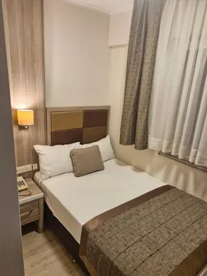 a small bed in a small room with a window at PERA ARYA Hotel in Istanbul