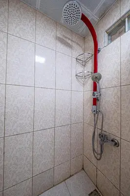 a shower with a red shower head in a bathroom at White Rose Apartments in Istanbul