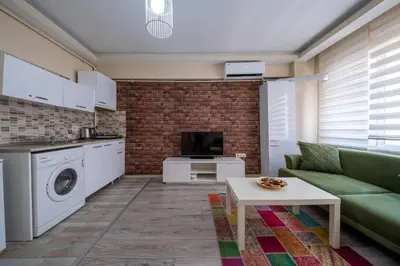 a living room with a green couch and a kitchen at White Rose Apartments in Istanbul