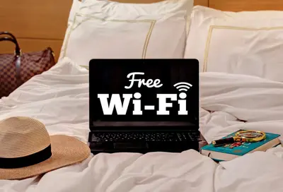 a laptop computer sitting on a bed with a hat at Almina Guest House in Istanbul
